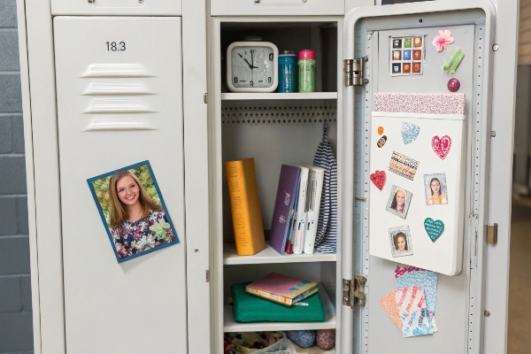 Open school locker with personal decorations and organized books.