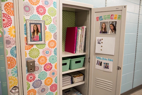 Decorated school locker with colorful wallpaper and organized shelves.