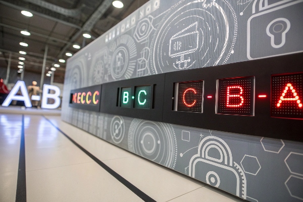 Digital display showing various locker codes with illuminated letters on a futuristic backdrop.