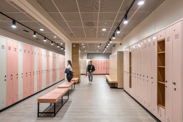 Stylish locker room with pink lockers and seating benches, perfect for modern facilities