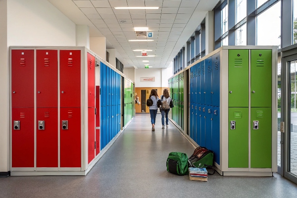 Colorful lockers in a bright hallway with students walking by.