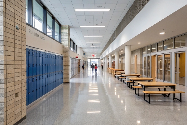 School hallway with blue lockers and benches.