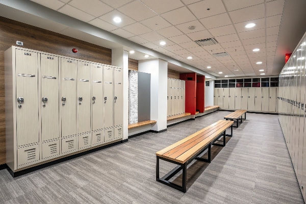 Spacious modern locker room with beige metal lockers and wooden benches