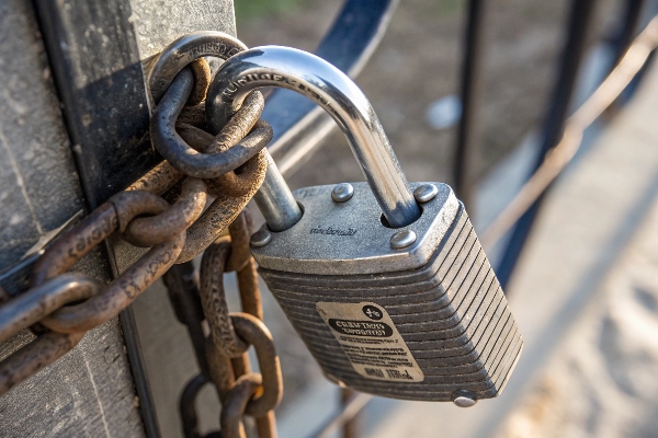 Close-up of a padlock securing a chain on a gate