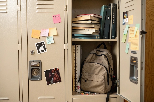 Open school locker with books, backpack, and sticky notes