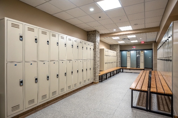 Row of lockers with wooden benches in a locker room