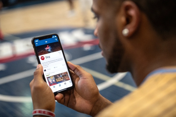 Person using a smartphone to check basketball game stats