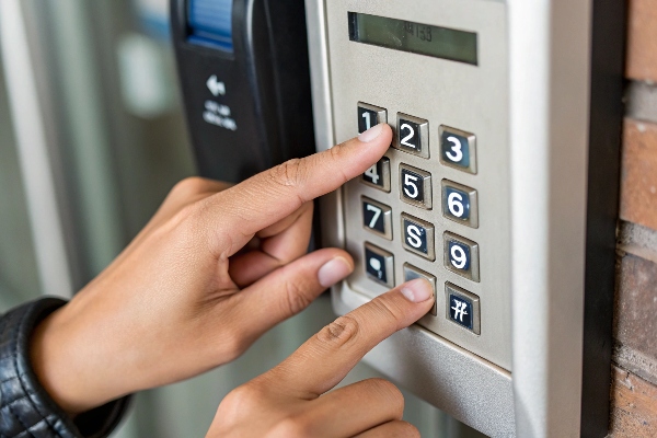 Person entering a code on a security keypad access system