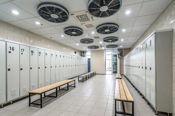 Locker room with lockers, benches, and overhead fans